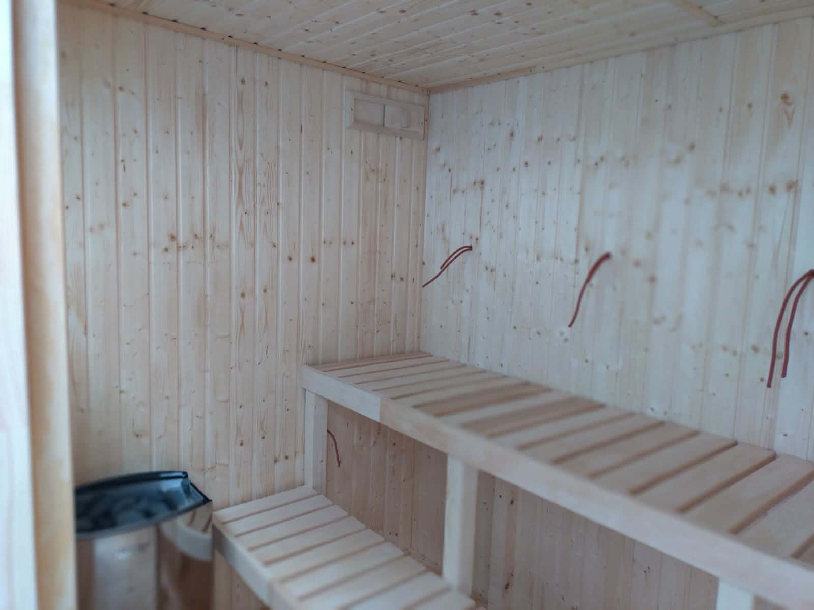 Wnętrze sauny z drewnianymi ławami pod skosem